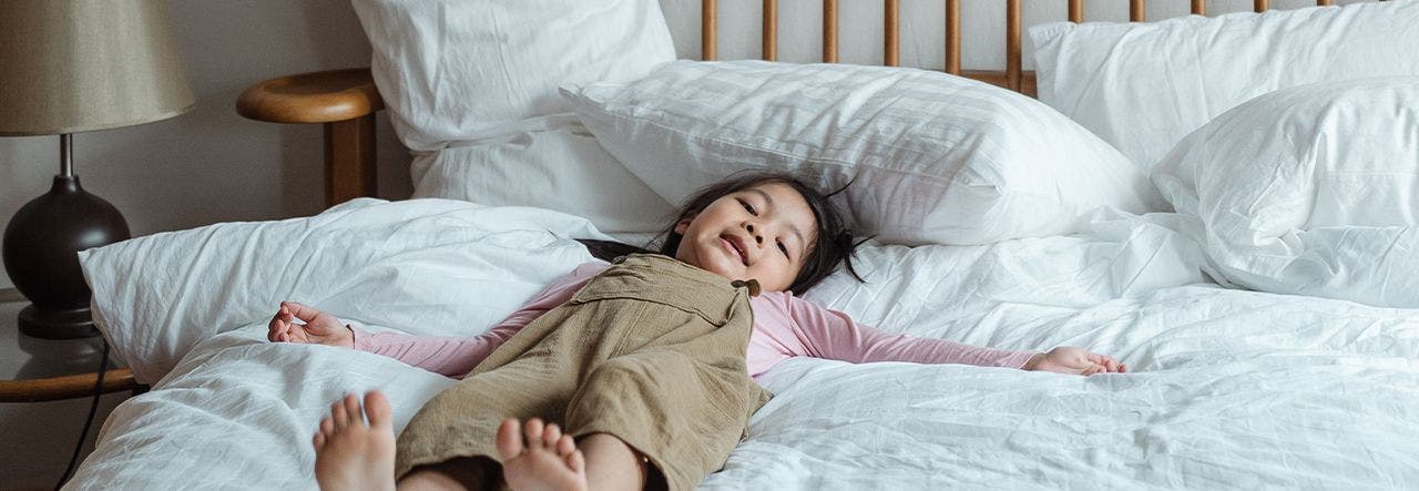 Young girl relaxing in a big, comfy bed