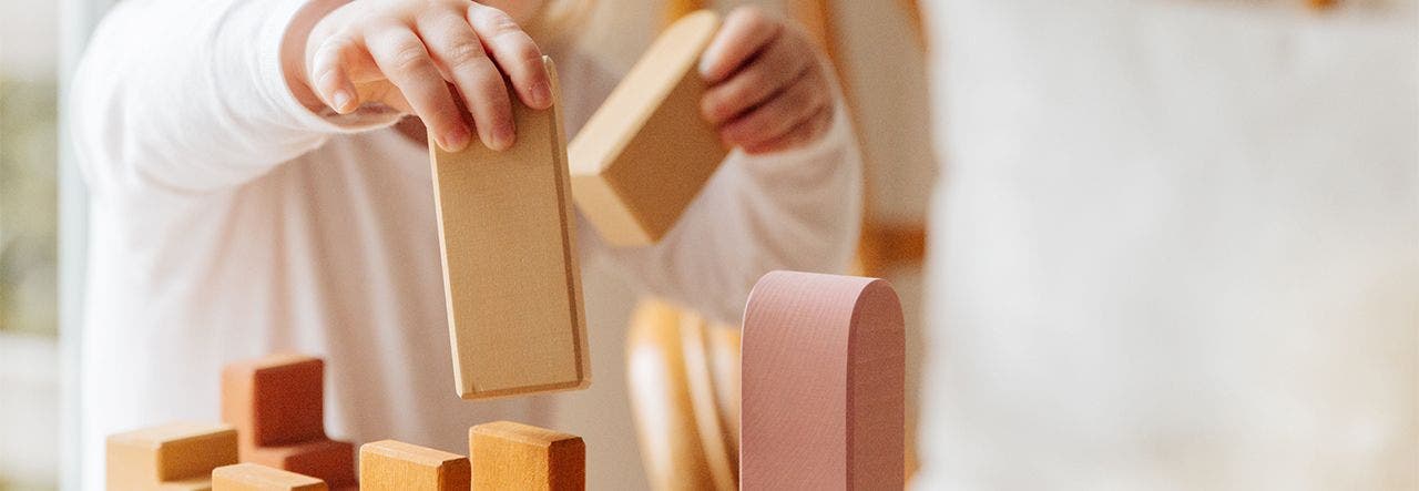 Toddler enjoying sensory play with wooden blocks