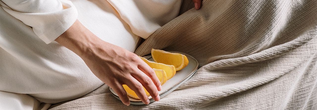 Pregnant woman eating fresh fruit slices