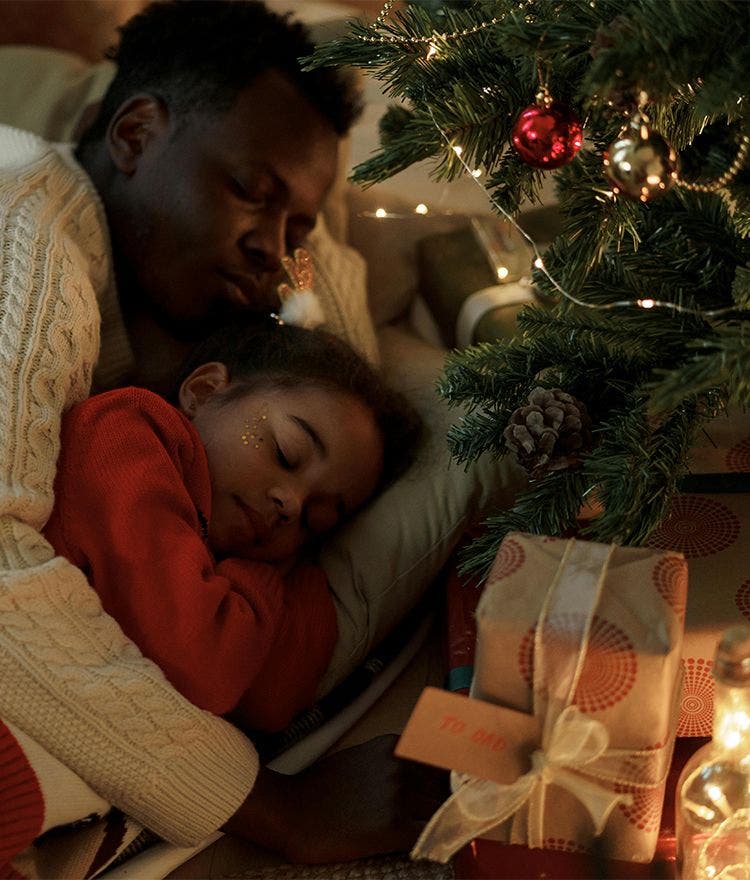 Parent and child embracing near christmas tree