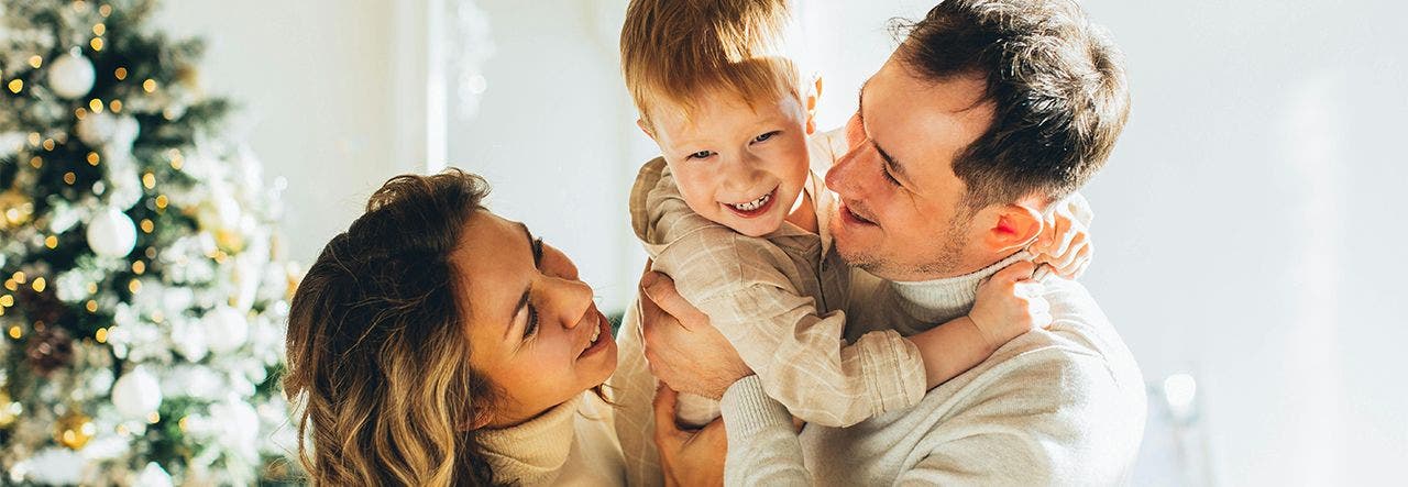 family embracing near christmas tree