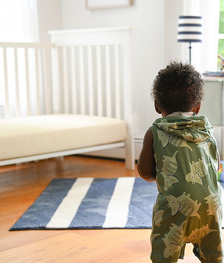baby standing in a nursery