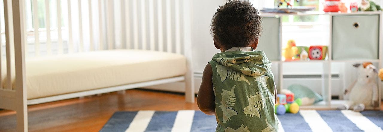 baby standing in a nursery