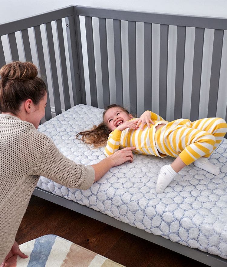 child laying on lullaby earth gentle start crib mattress