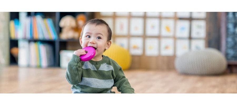 toddler chewing on plastic toy