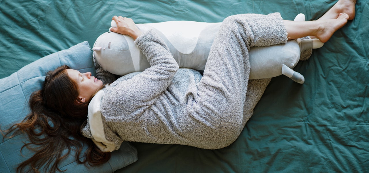 Pregnant person side-sleeping with a pregancy pillow
