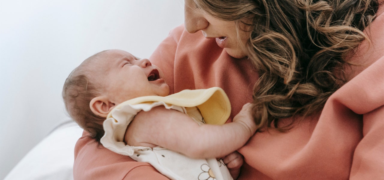 Mother cuddling her fussy baby and comforting them