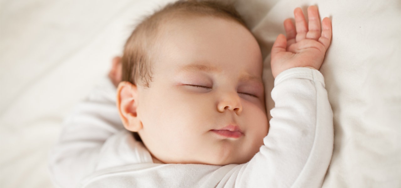 Baby lying on their back in a deep sleep
