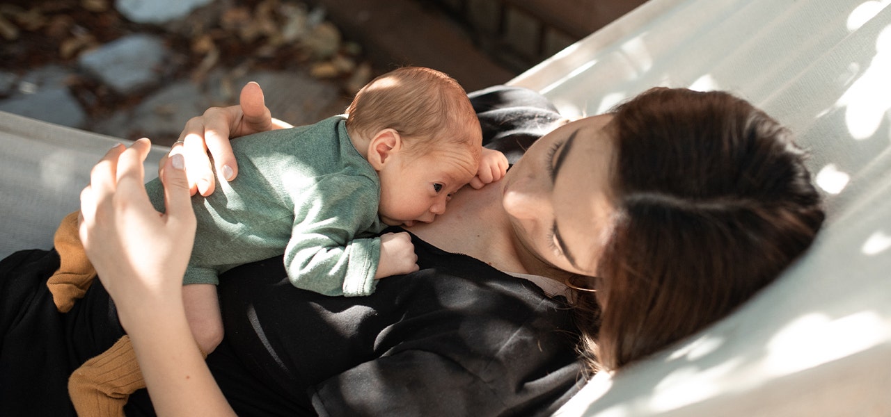 Newborn baby lying awake in their mother's chest