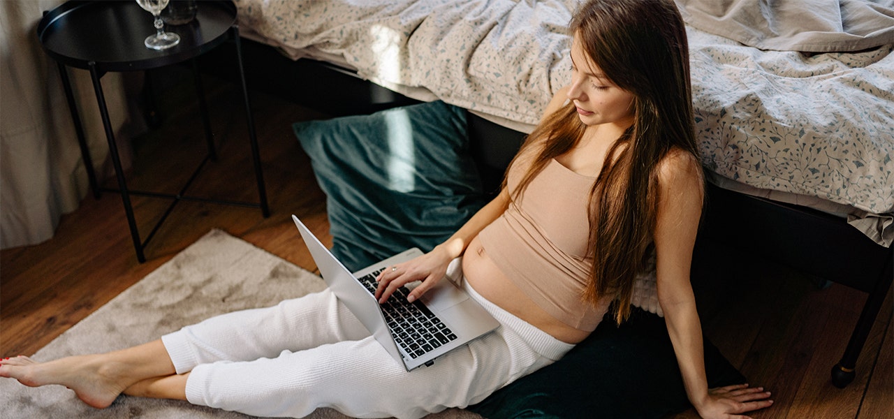 Pregnant woman researching flame retardants on her laptop