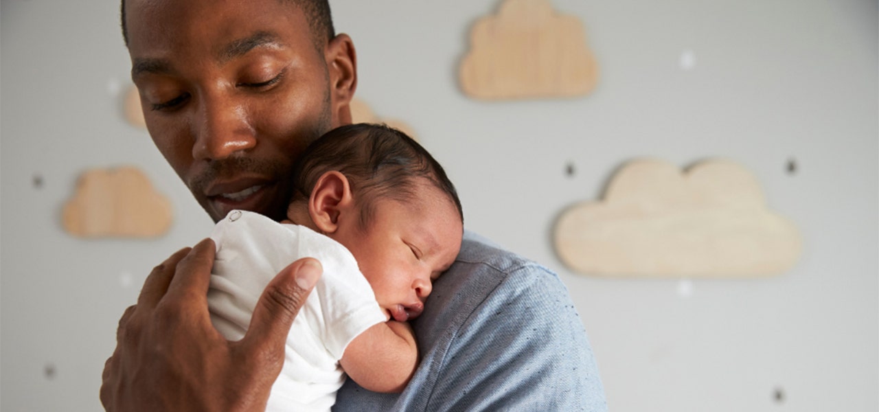 Father snuggling newborn baby