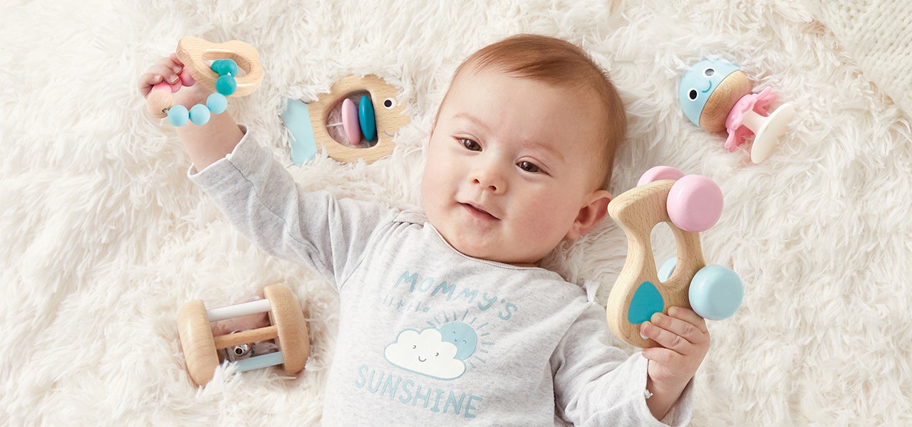 Baby smiling and playing with wooden Hape Toys