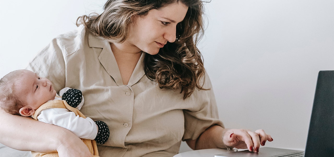 Mother with newborn, researching products online to avoid greenwashing