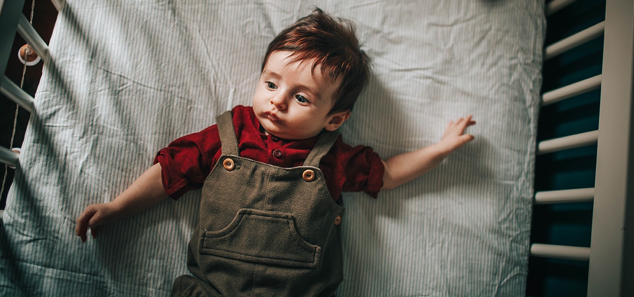 Infant lying awake on their crib mattress