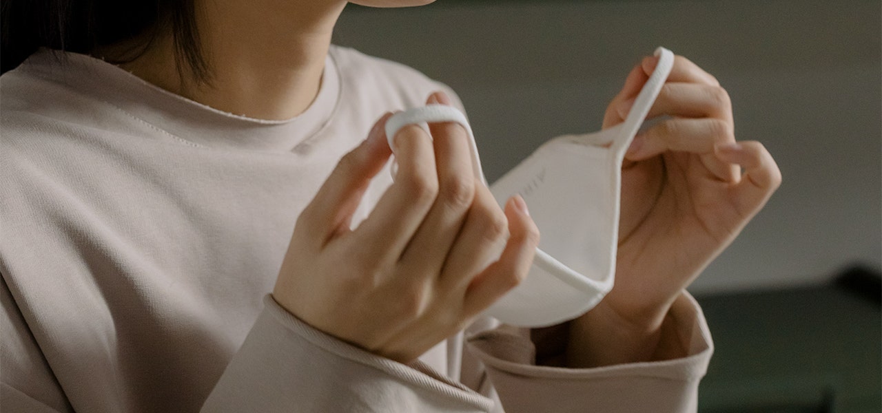 Person putting on a mask to protect themself from mold spores