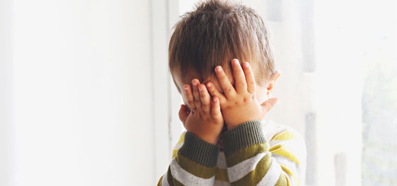 Toddler covering their face with their hands