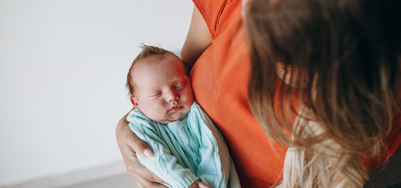 Infant napping in their mother's arms