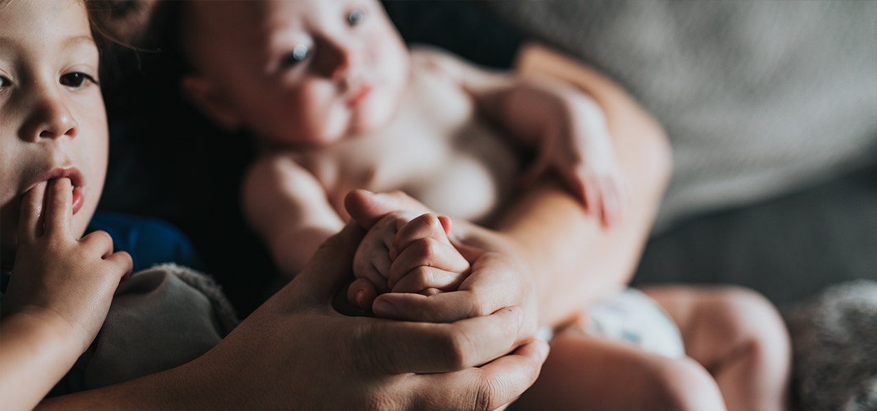 Parent snuggling with an overstimulated baby to help calm them