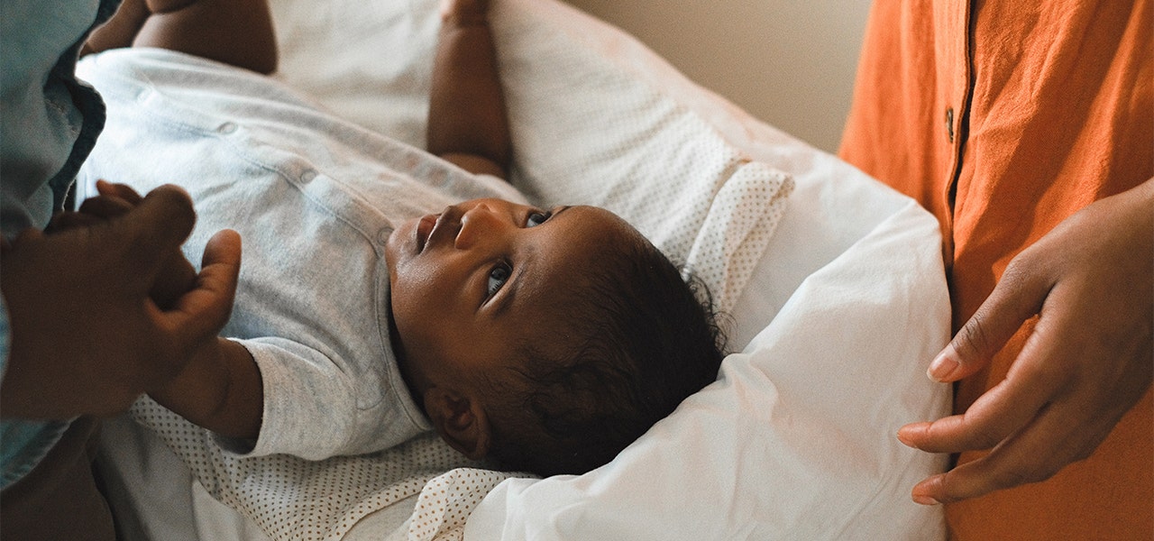 Baby lying on changing table and looking up at parent