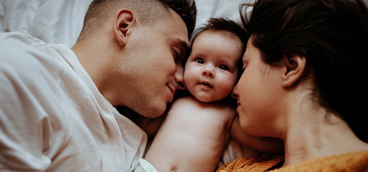 Mom and Dad snuggling baby together