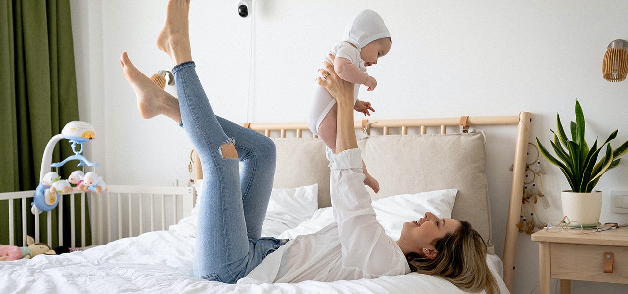 Mom playing with her baby on the bed