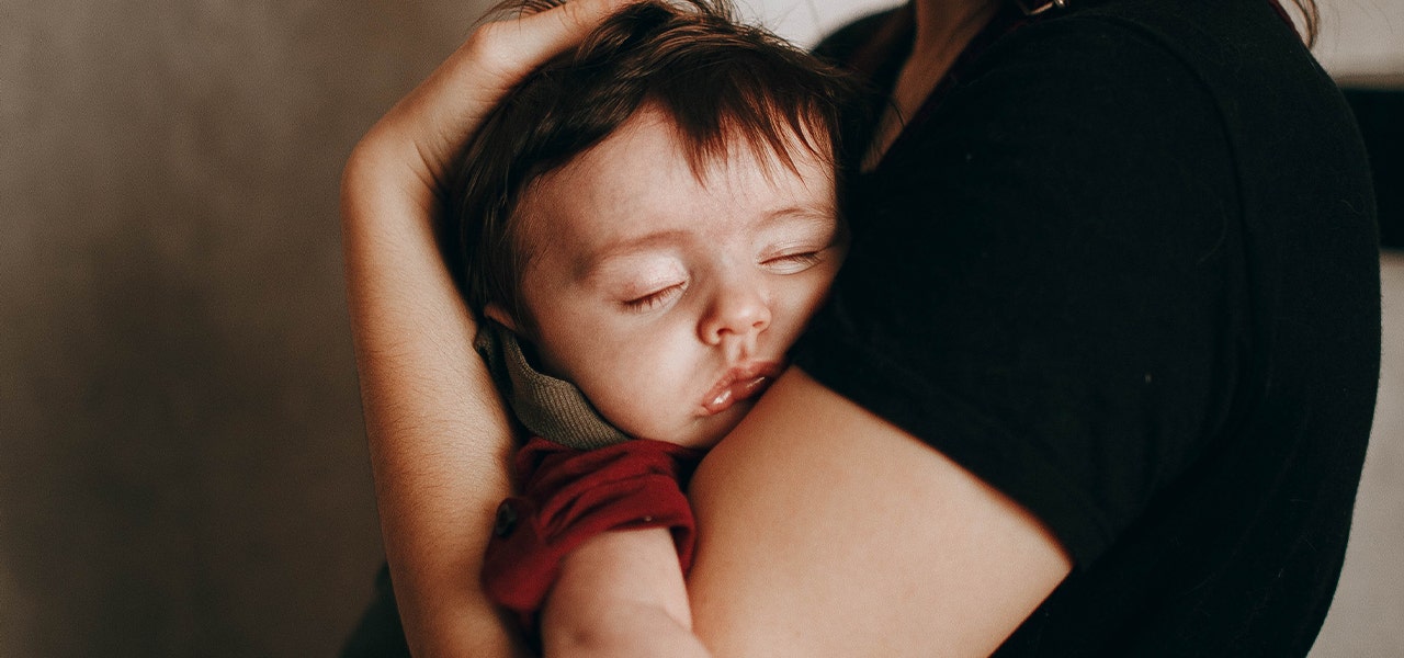 Baby sleeping soundly in parent's arms