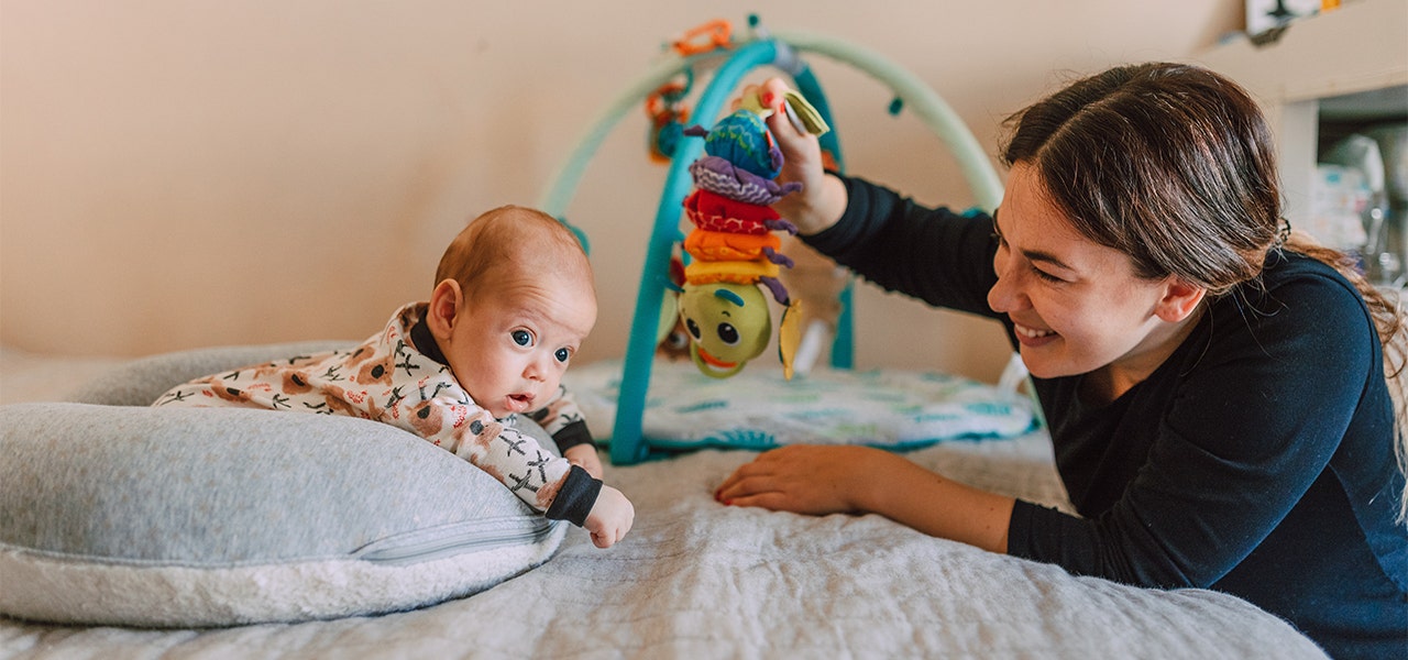 Mom smiling at Baby as they enjoy tummy time