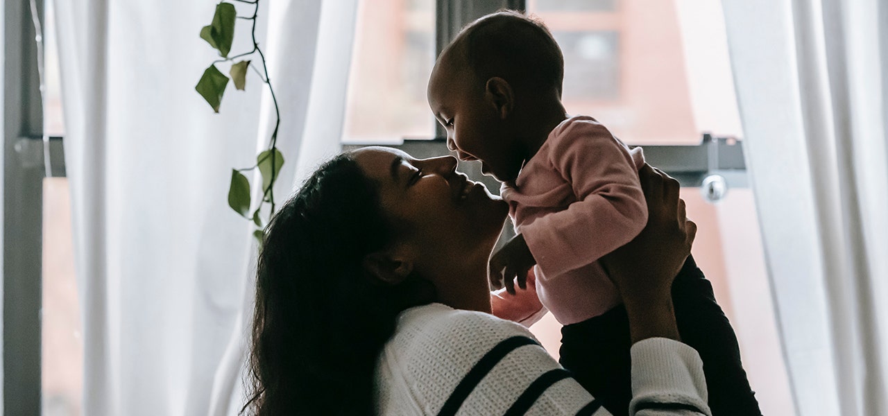 Mother lifting happy baby and smiling