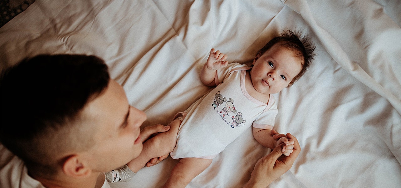 Father playing with wide away baby