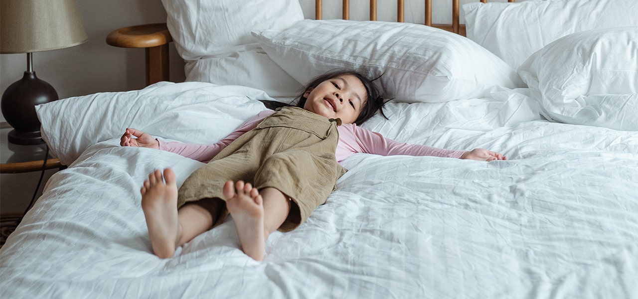 Young girl lying on a fresh, clean bed