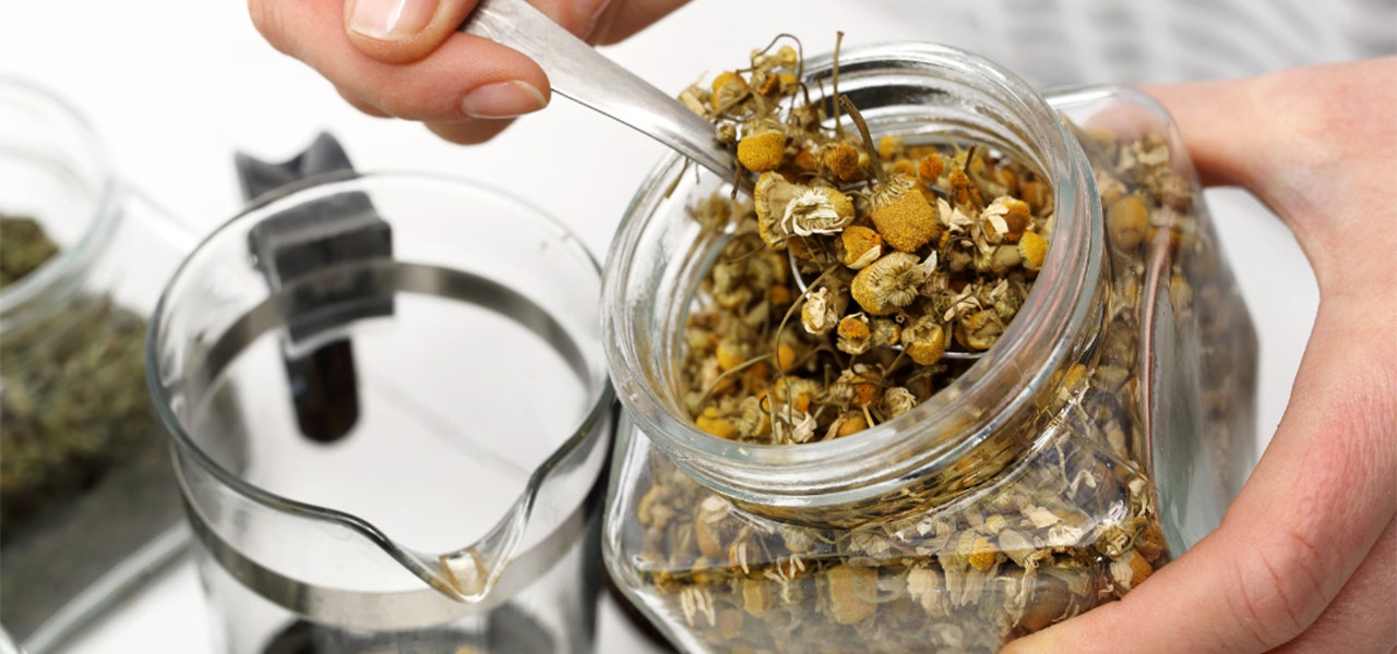 Glass jar filled with dried chamomile for tea