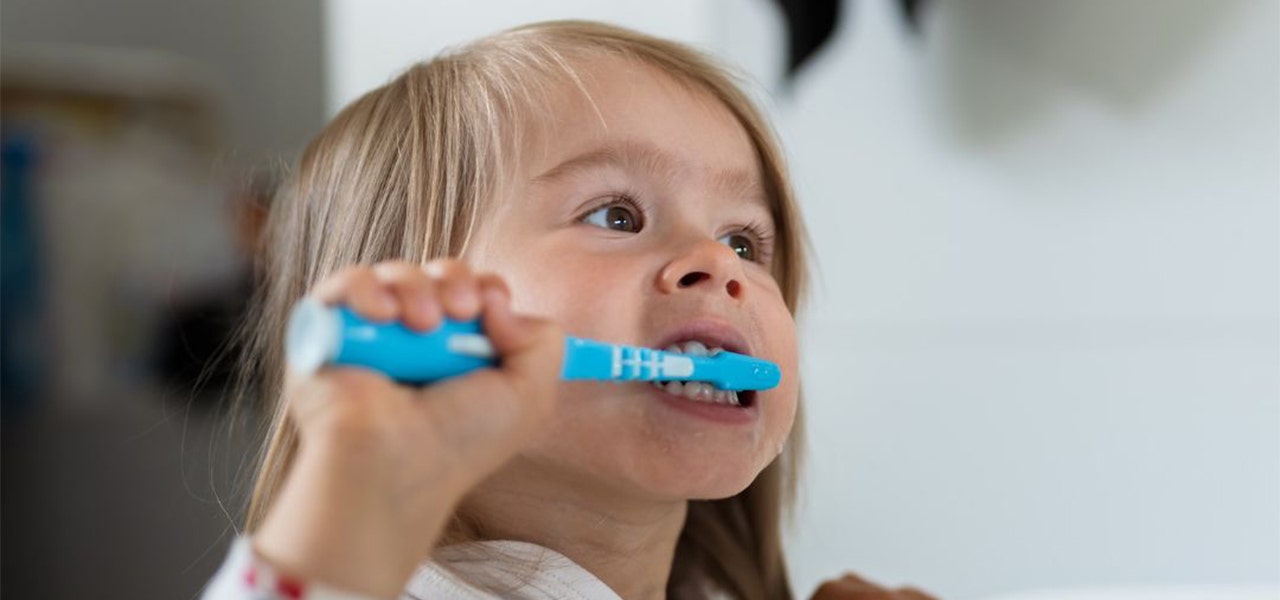 Toddler brushing their teeth before bedtime