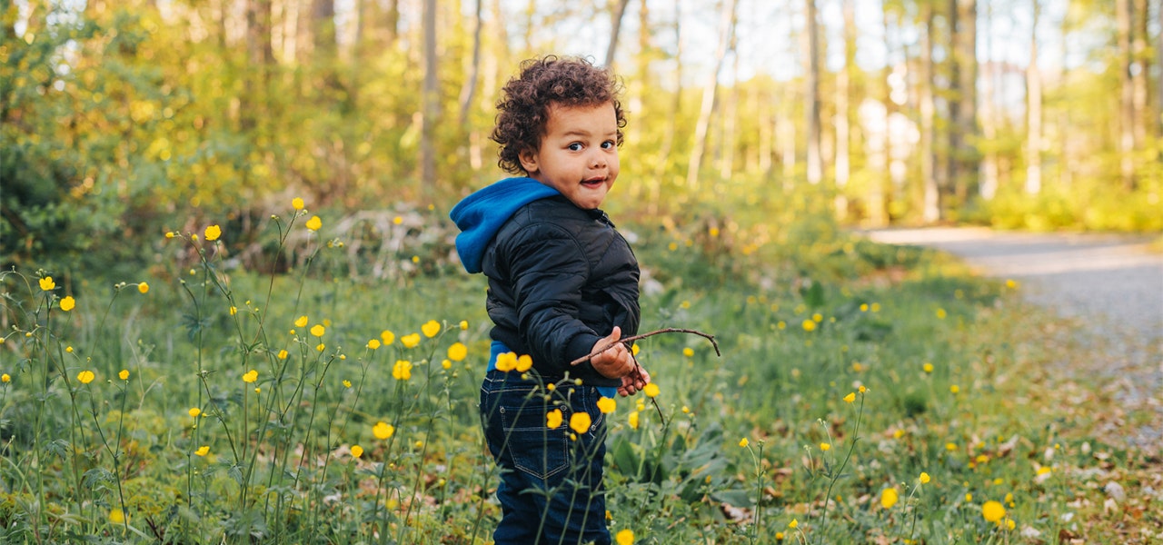 Toddler outside in a field of yellow flowers