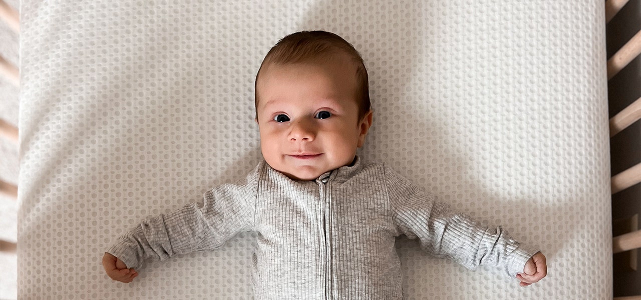 Baby lying on non-toxic crib mattress