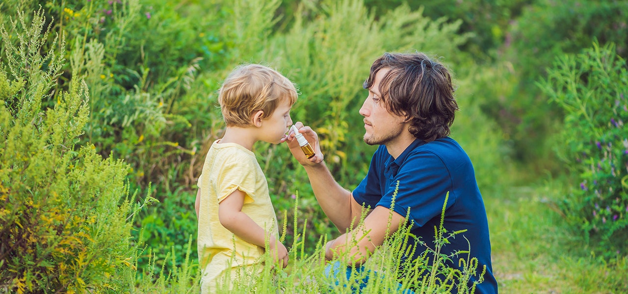 parent administering saline spray to child outside