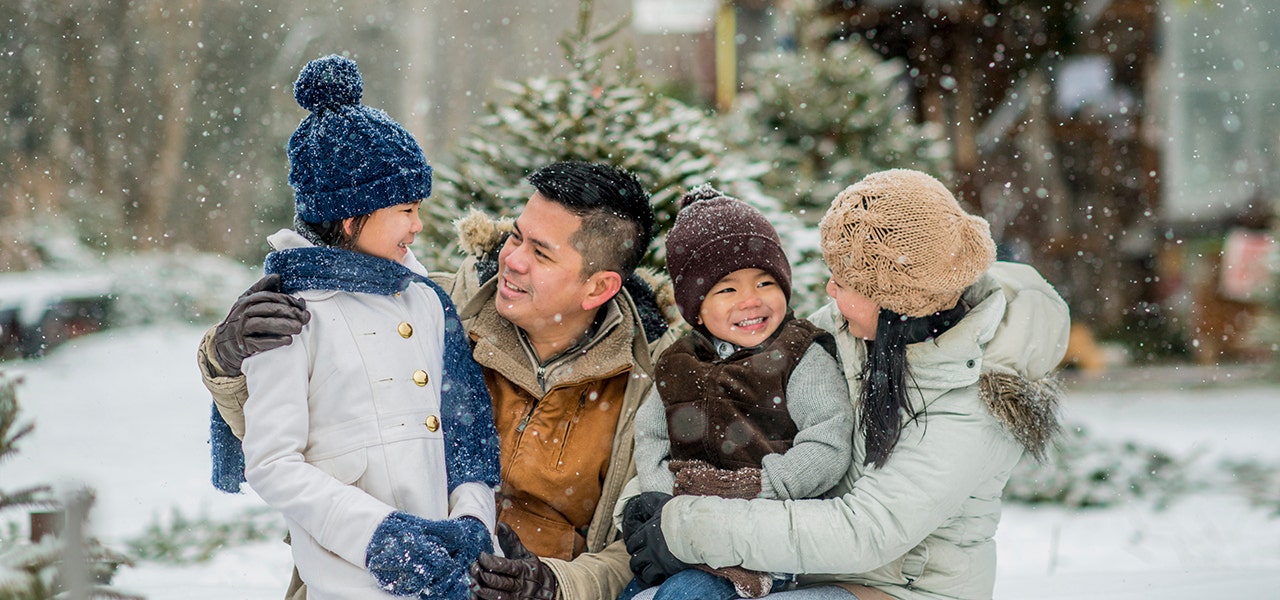 family sitting together in the snow