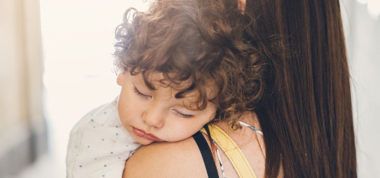 Toddler falling asleep in their mother's arms