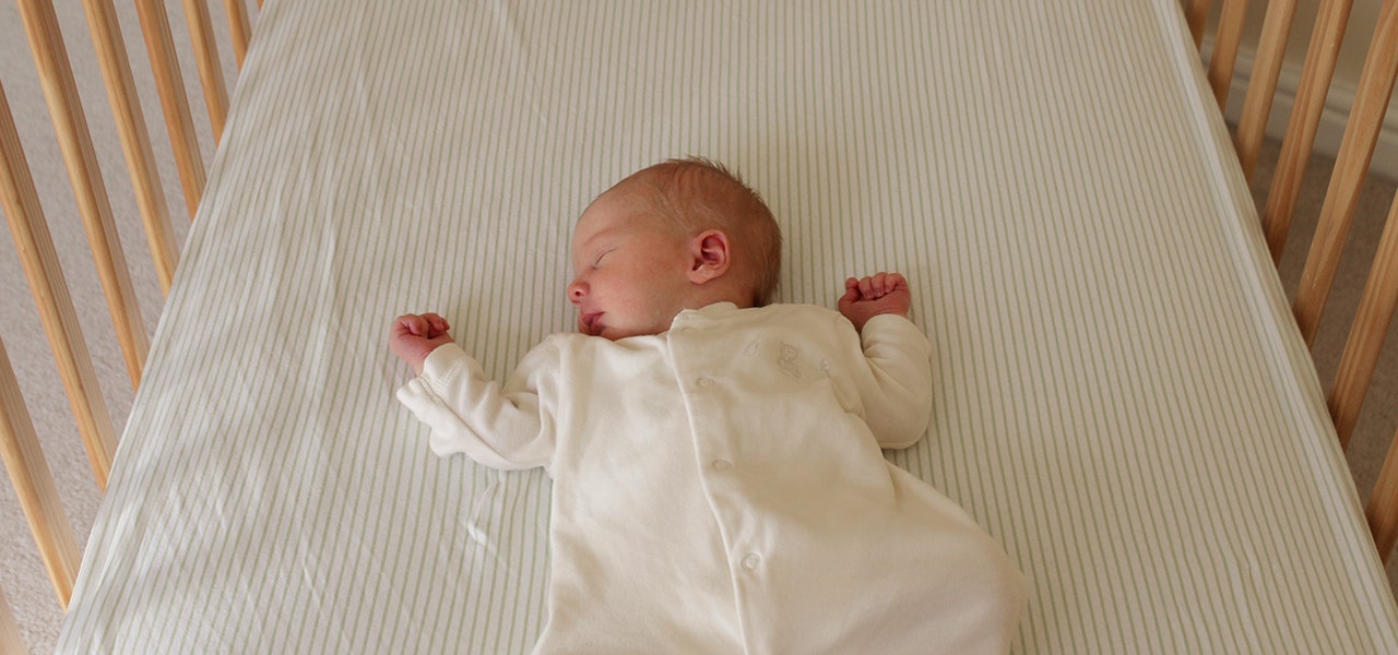 baby sleeping on crib mattress