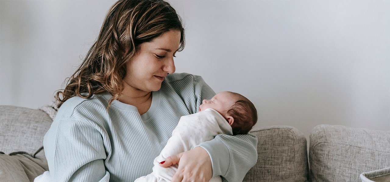 parent holding swaddled baby