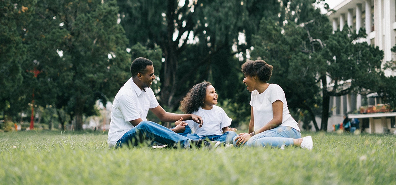 family sitting together outside in the grass